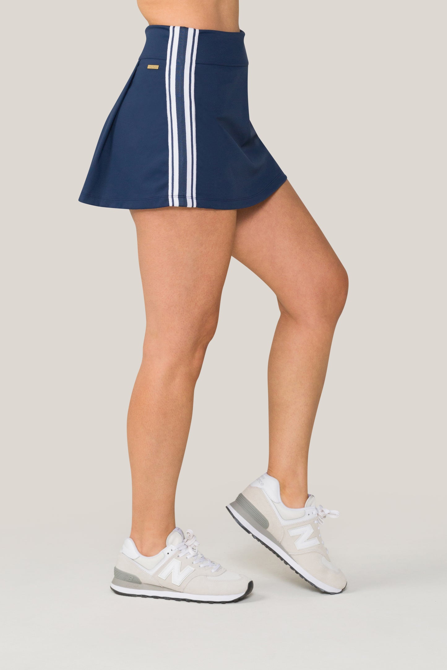 Alala women's tennis skort in navy with stripe detail