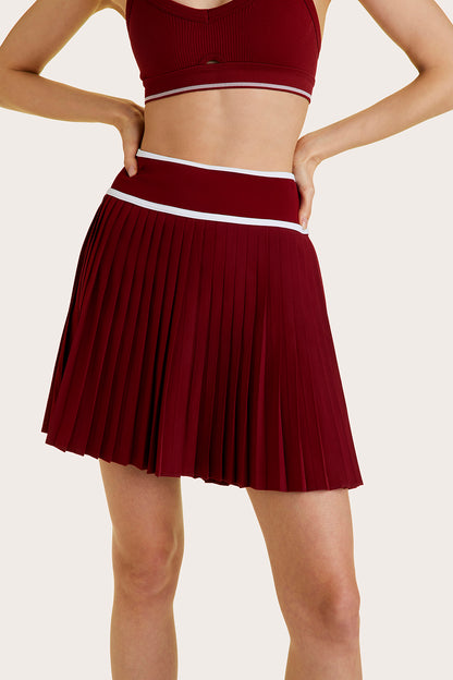 Alala women's longer length pleated tennis skort in dark red
