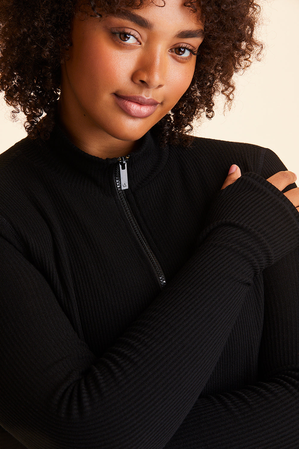 Front view of Alala Women's Luxury Athleisure black ribbed zip up crop jacket in plus size