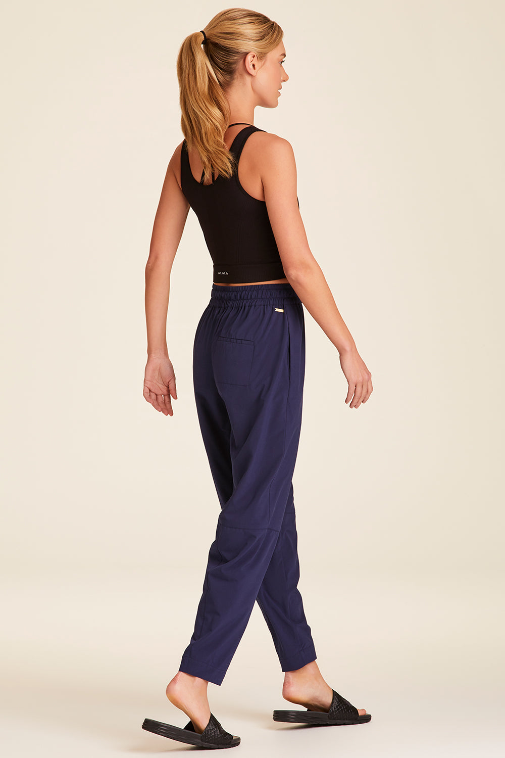 Full body back view of Alala Luxury Women's Athleisure commuter pant in navy