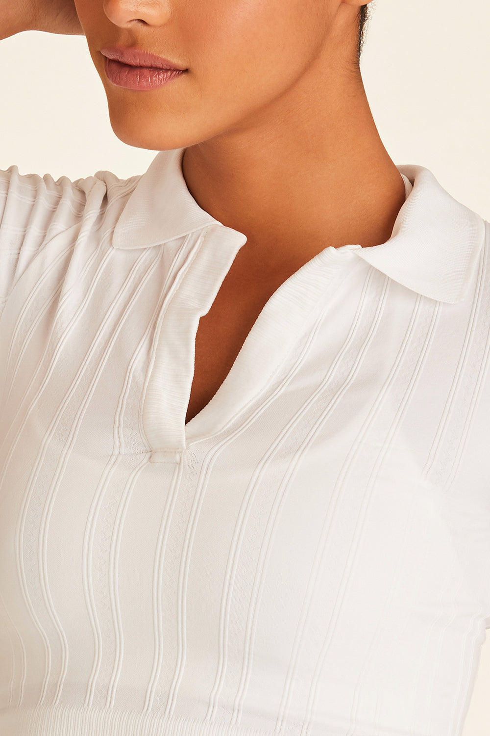 Closeup of model wearing white Seamless Polo showing collar details