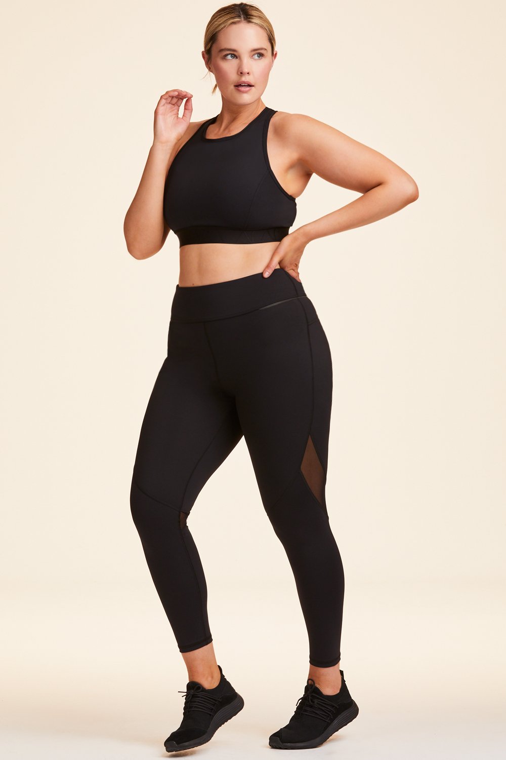 3/4 view of Alala Women's Luxury Athleisure black tight with mesh paneling on back of knees