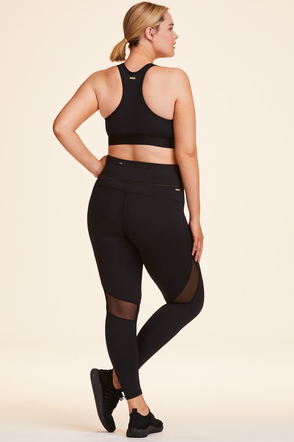 Back view of Alala Women's Luxury Athleisure black tight with mesh paneling on back of knees