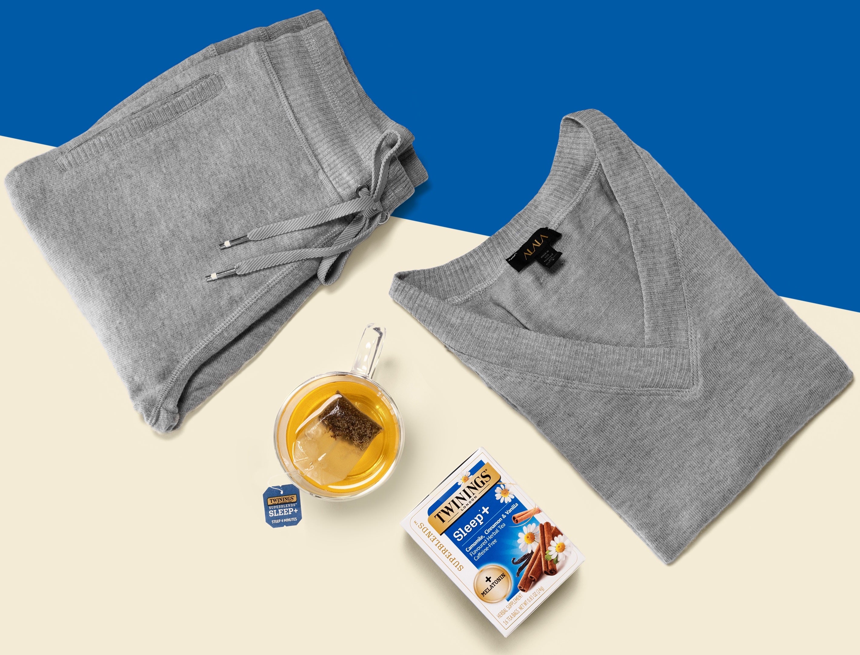 The "Wander Sweatshirt" and "Wander Sweatpants" in grey next to Twinings Sleep+ Tea.