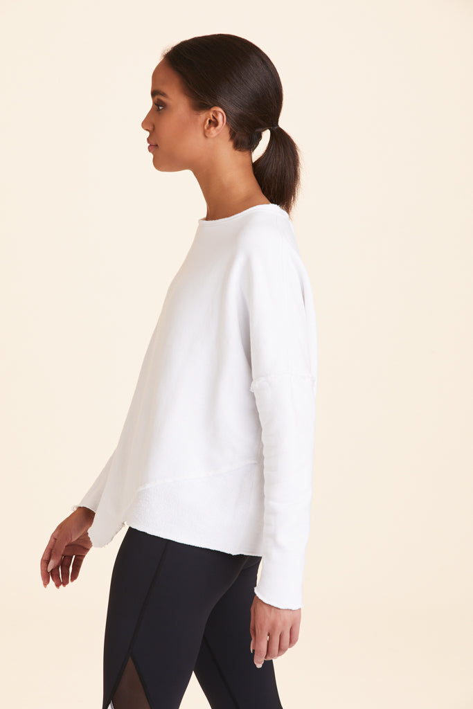 Side view of Alala Women's Luxury Athleisure white sweatshirt with distressed details on seams