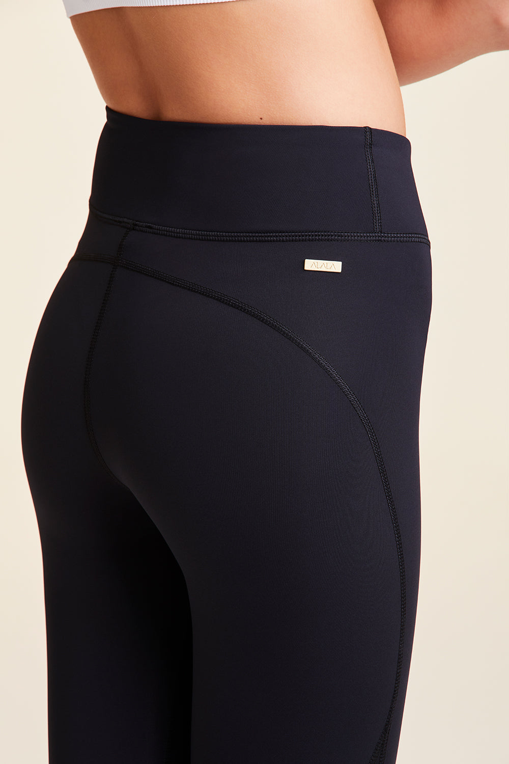 Close-up back view of Alala Women's Luxury Athleisure black tight with minimal mesh detail