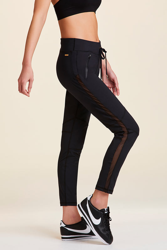 Side view of Alala Women's Luxury Athleisure black sweatpant with sheer mesh side panel