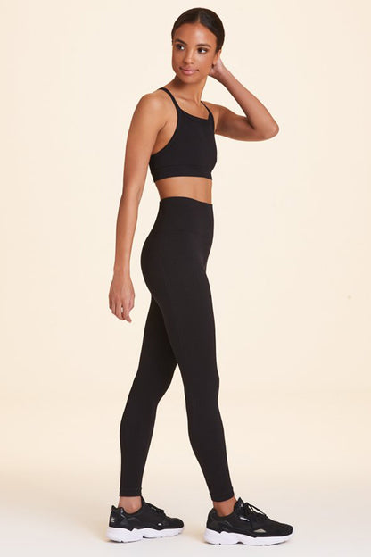 Side view of Alala Women's Luxury Athleisure flow seamless tight in black with rib detailing