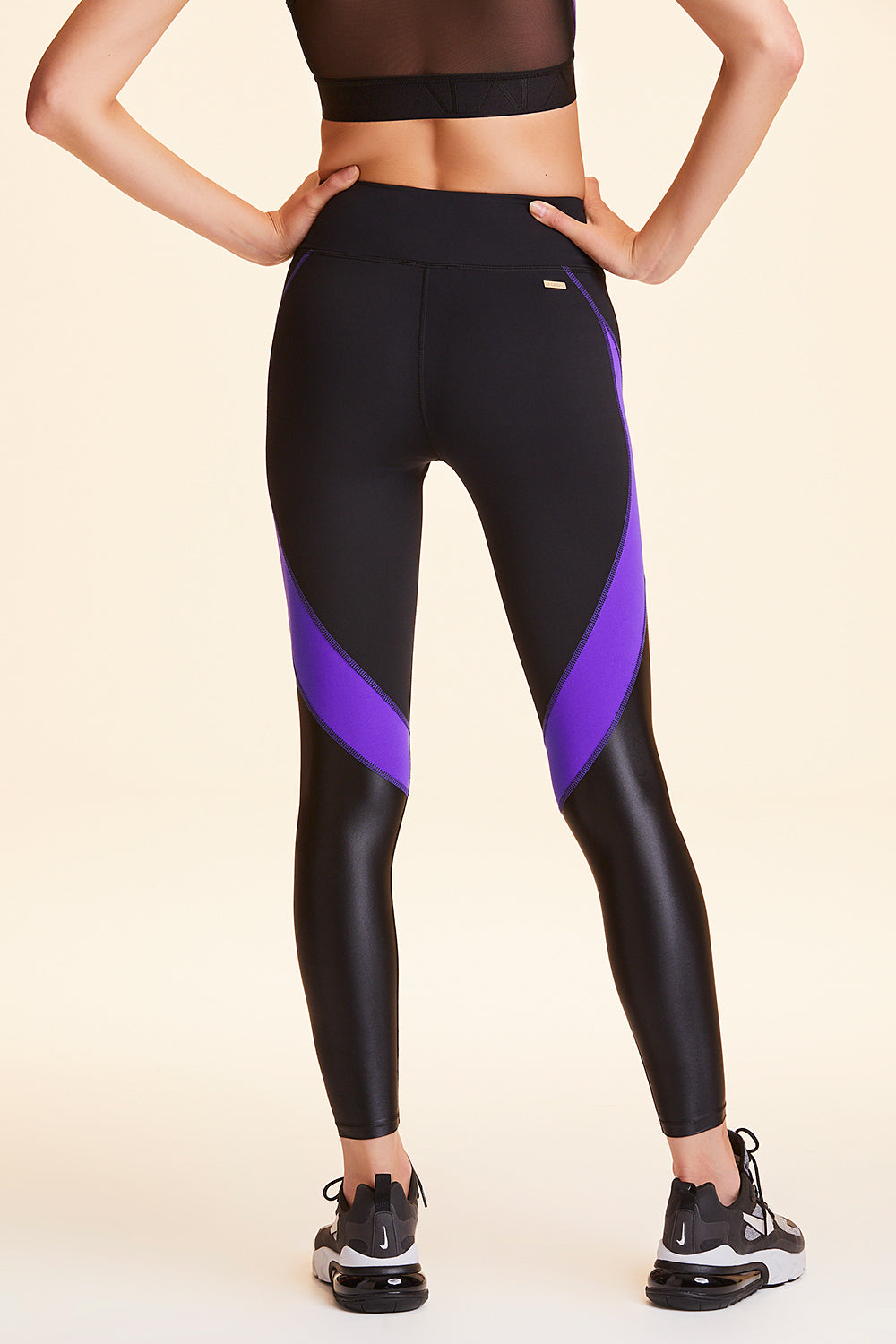 Back view of Alala Women's Luxury Athleisure black and purple color-blocked tight