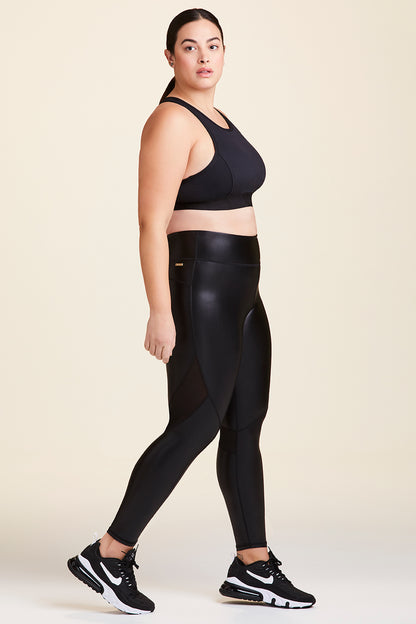 Side view of Alala Women's Luxury Athleisure shiny black tight with mesh paneling on back of knees in plus size