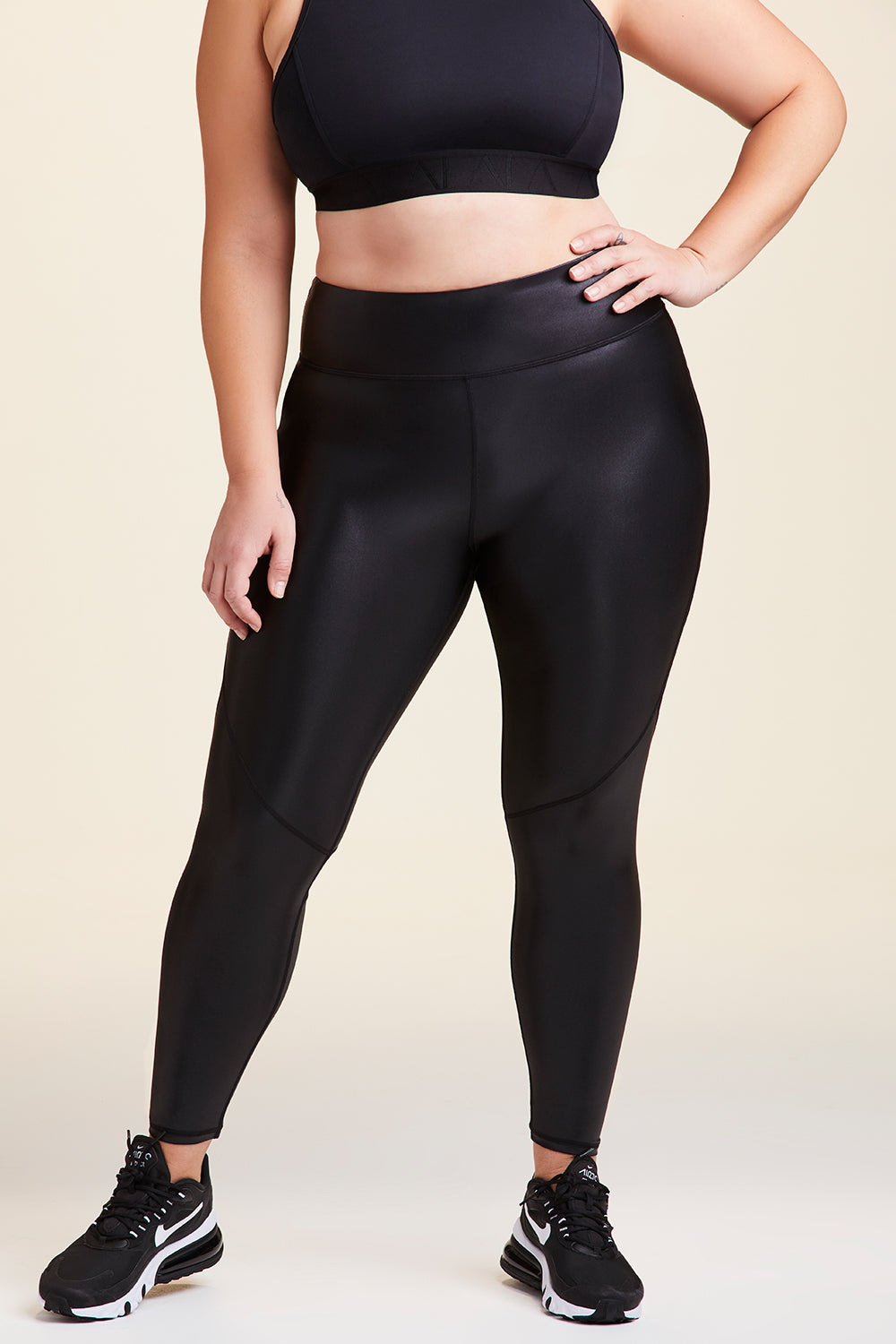 Front view of Alala Women's Luxury Athleisure shiny black tight with mesh paneling on back of knees in plus size