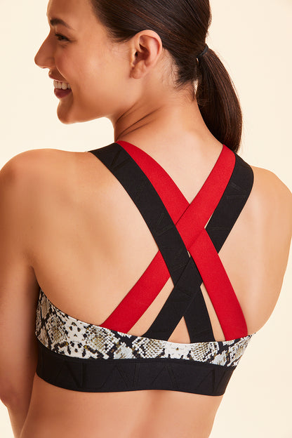 Back view of Alala Women's Luxury Athleisure snakeskin sports bra with red and black cross back straps