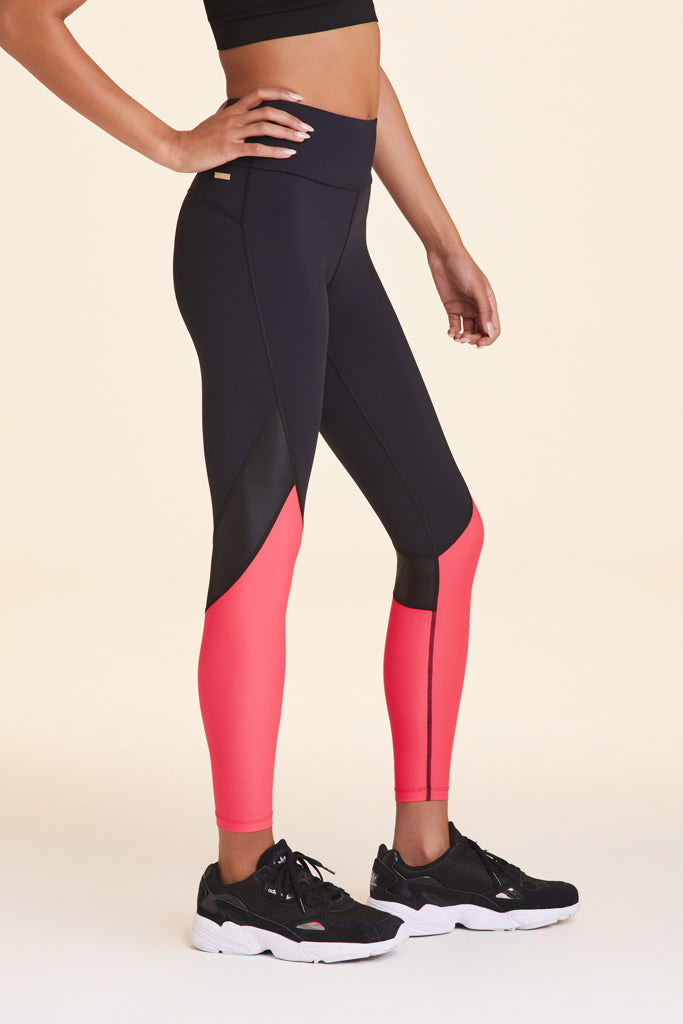 Side view of Alala Women's Luxury Athleisure black and watermelon color-blocked tight