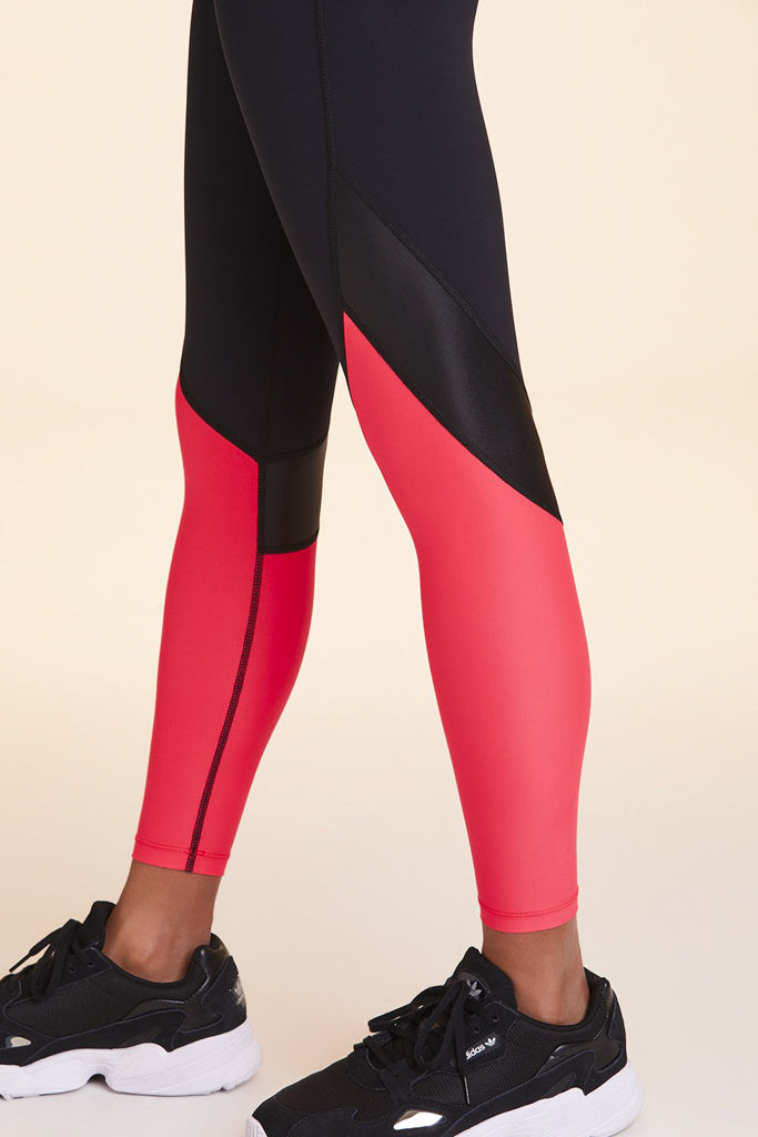 Side view close-up of Alala Women's Luxury Athleisure black and watermelon color-blocked tight