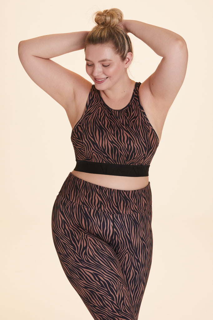 Front view of Alala Women's Luxury Athleisure brown and black tiger-striped racerback bra in plus size