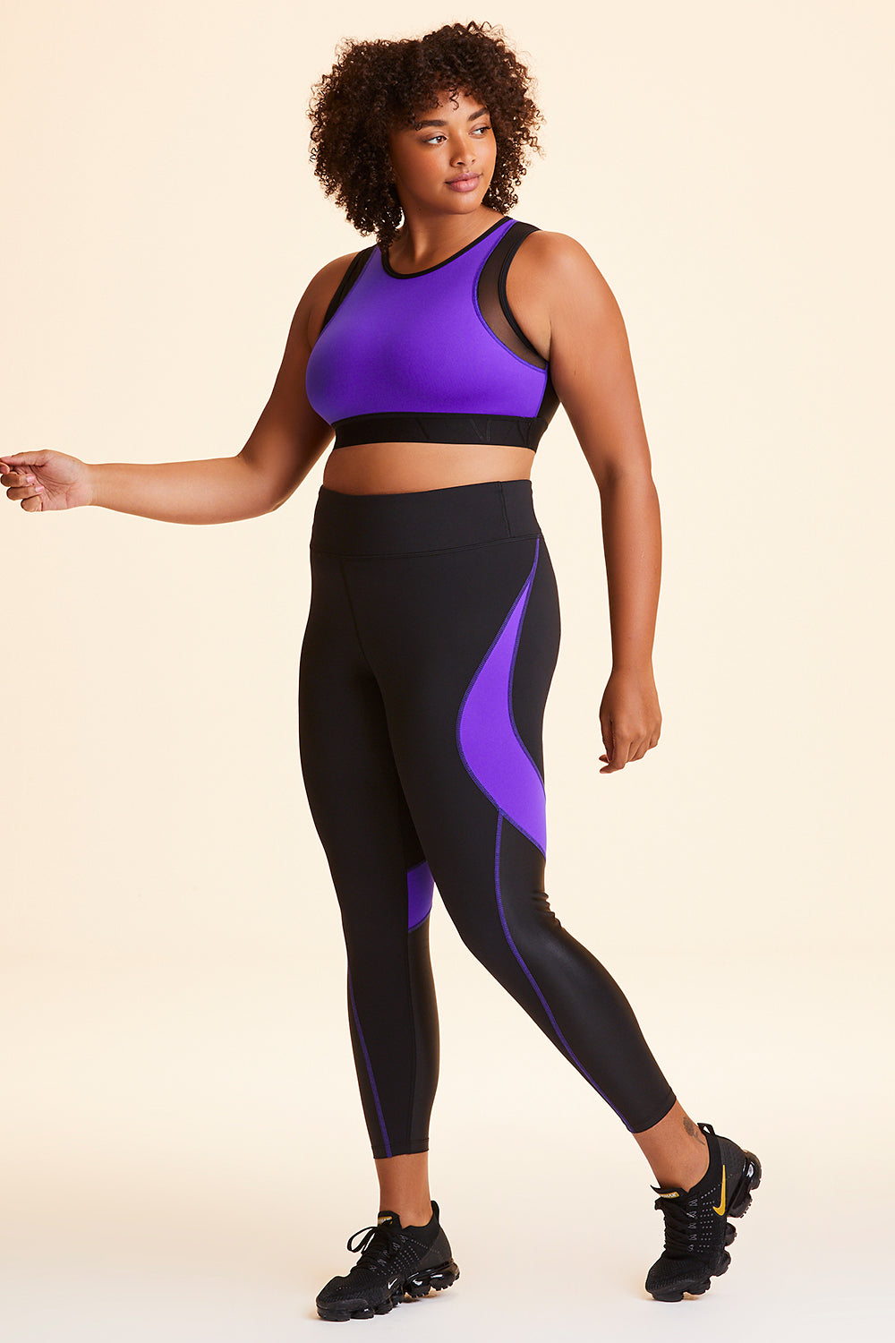 3/4 view of Alala Women's Luxury Athleisure black and purple color-blocked tight in plus size