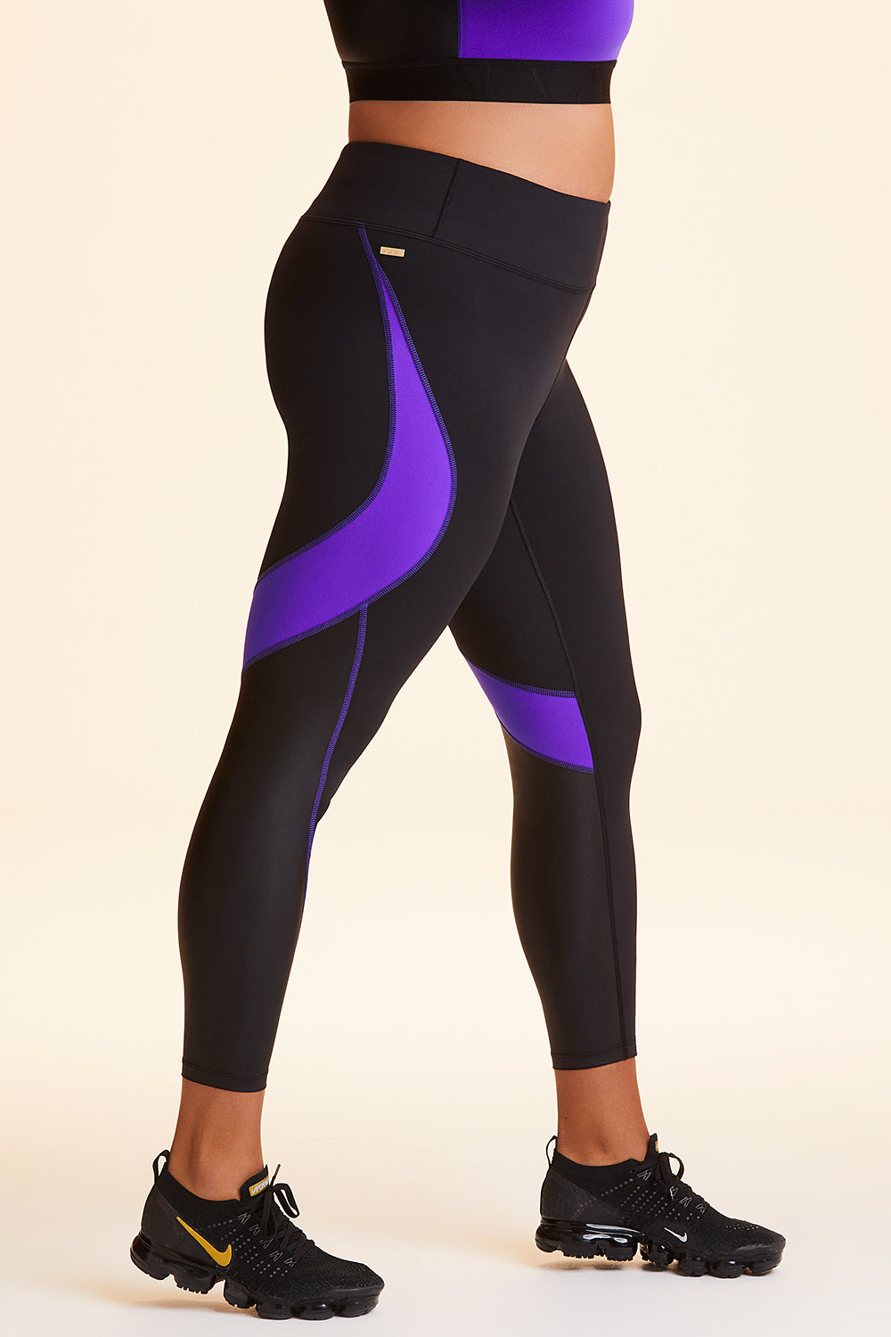 Side view of Alala Women's Luxury Athleisure black and purple color-blocked tight in plus size