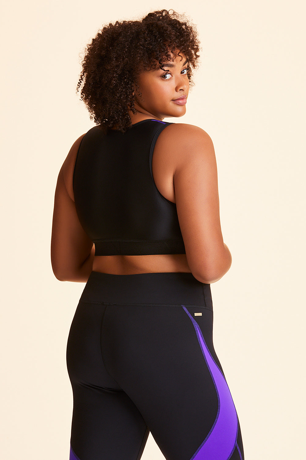 3/4 back view of Alala Women's Luxury Athleisure black and purple color-blocked sports bra