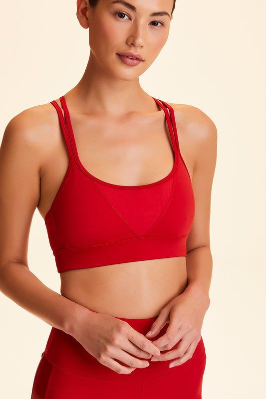 Front view of Alala Women's Luxury Athleisure ruby red sports bra with double crossover straps