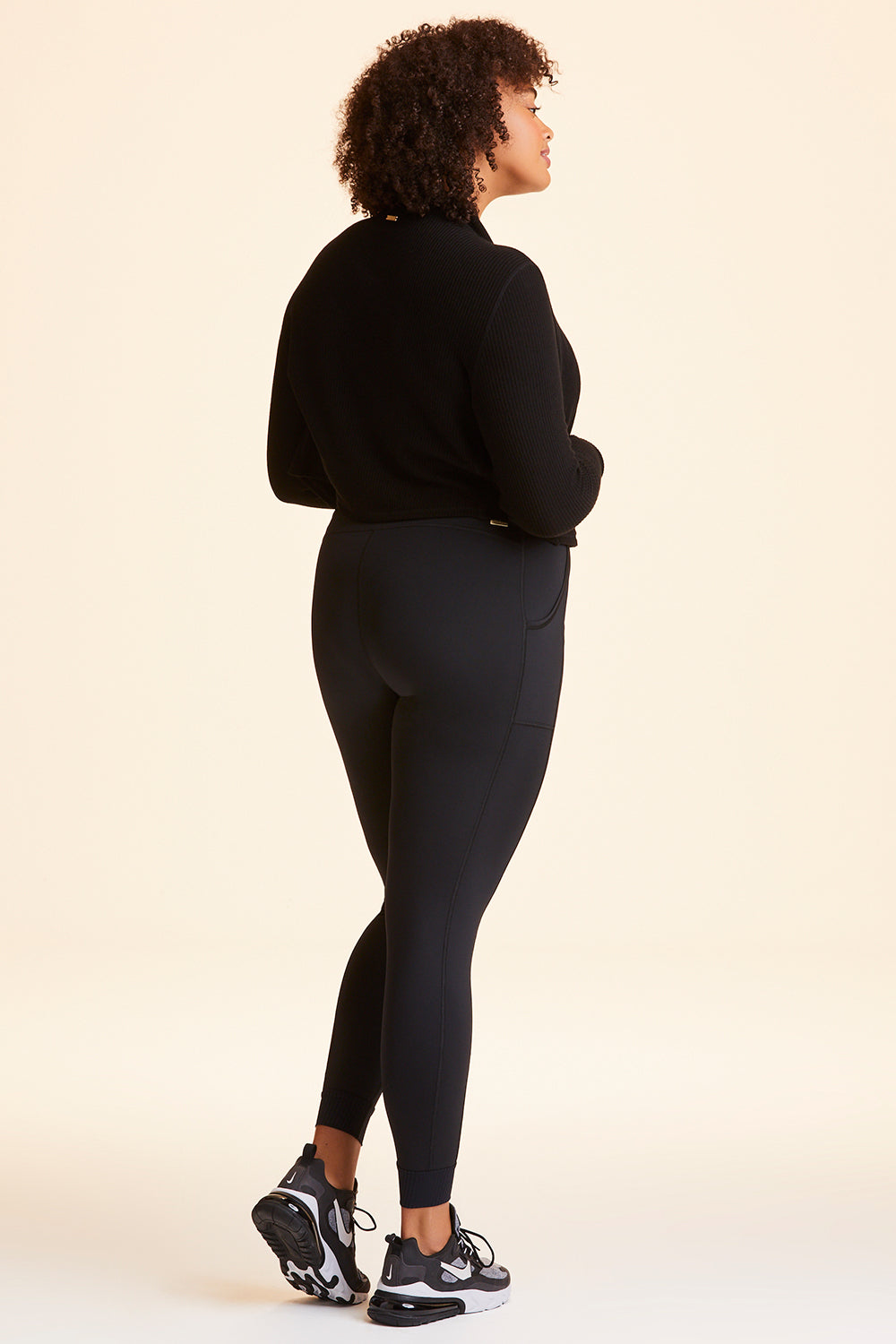 Side view of Alala Women's Luxury Athleisure black jogger-style tight in plus size