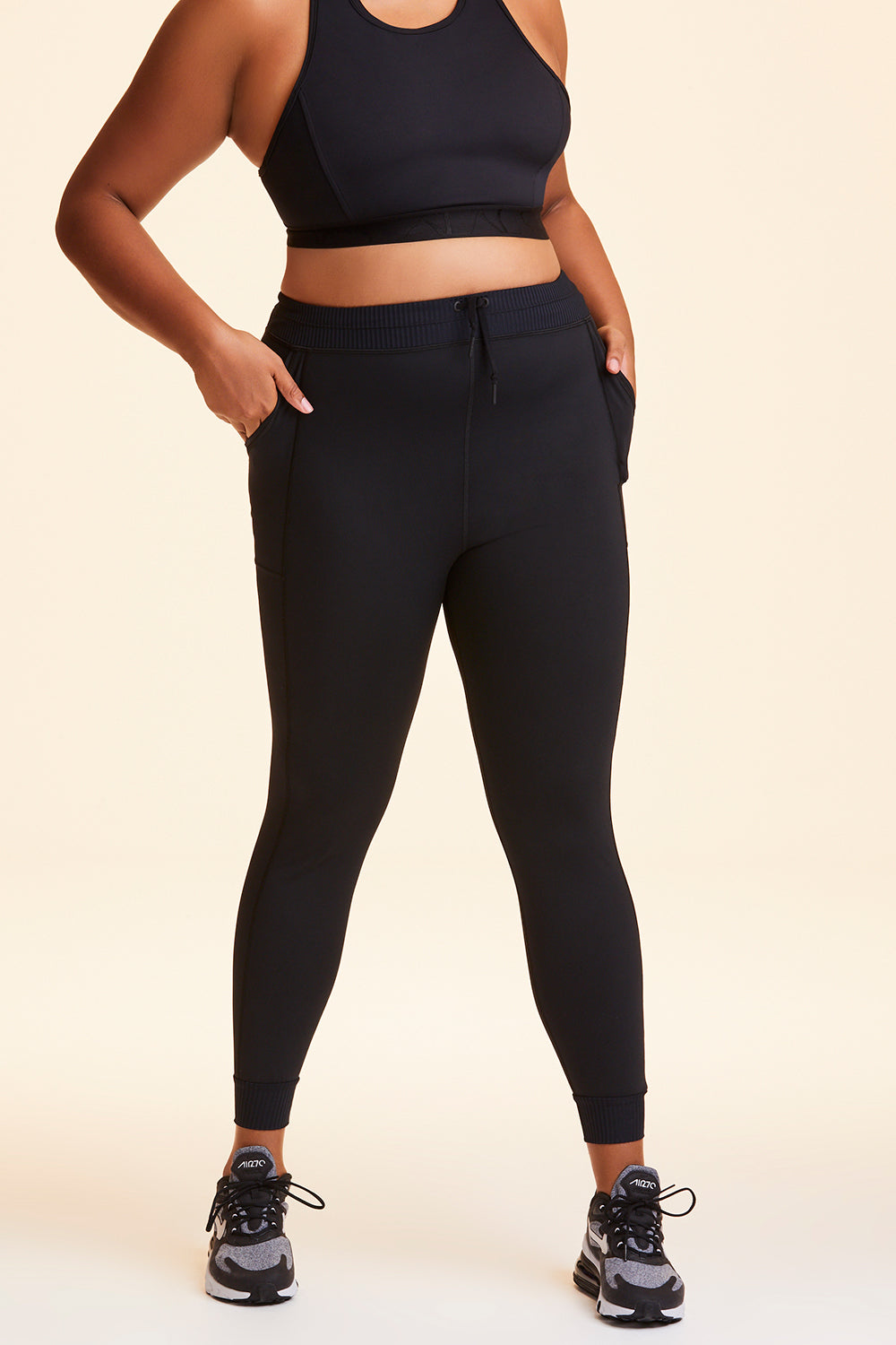 Front view of Alala Women's Luxury Athleisure black jogger-style tight in plus size