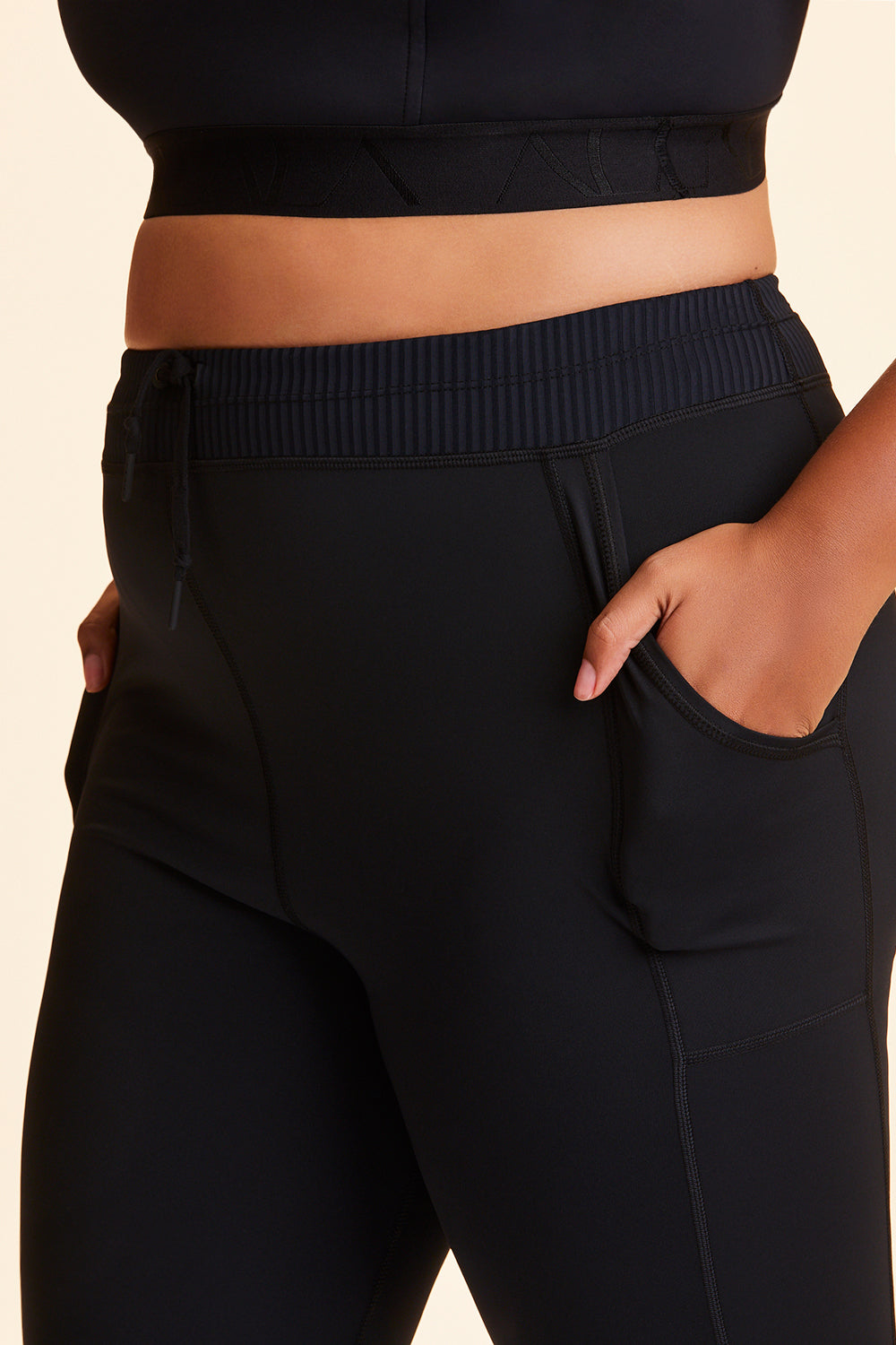 Front view of Alala Women's Luxury Athleisure black jogger-style tight in plus size