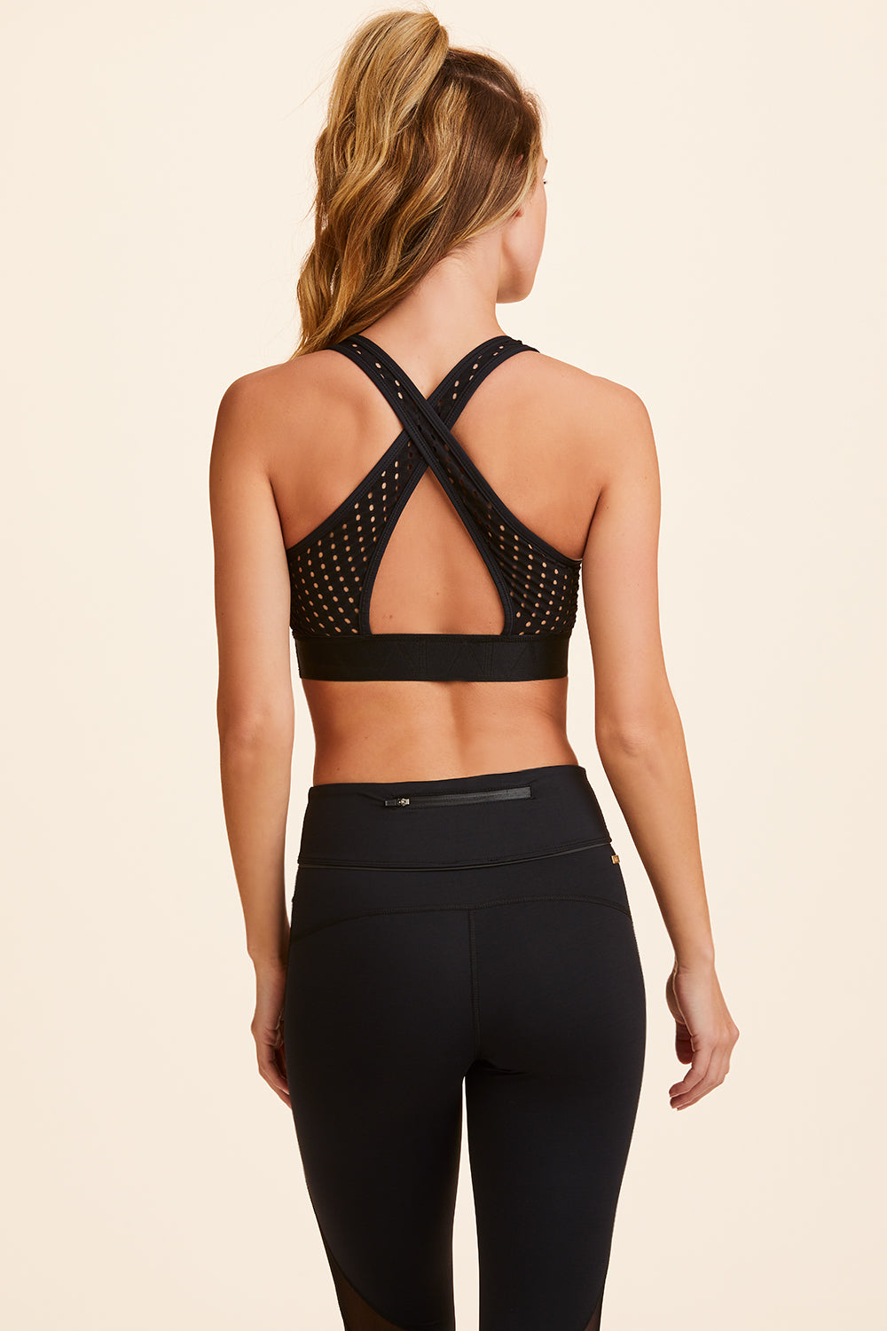 Back view of Alala Women's Luxury Athleisure black bra with cross back straps