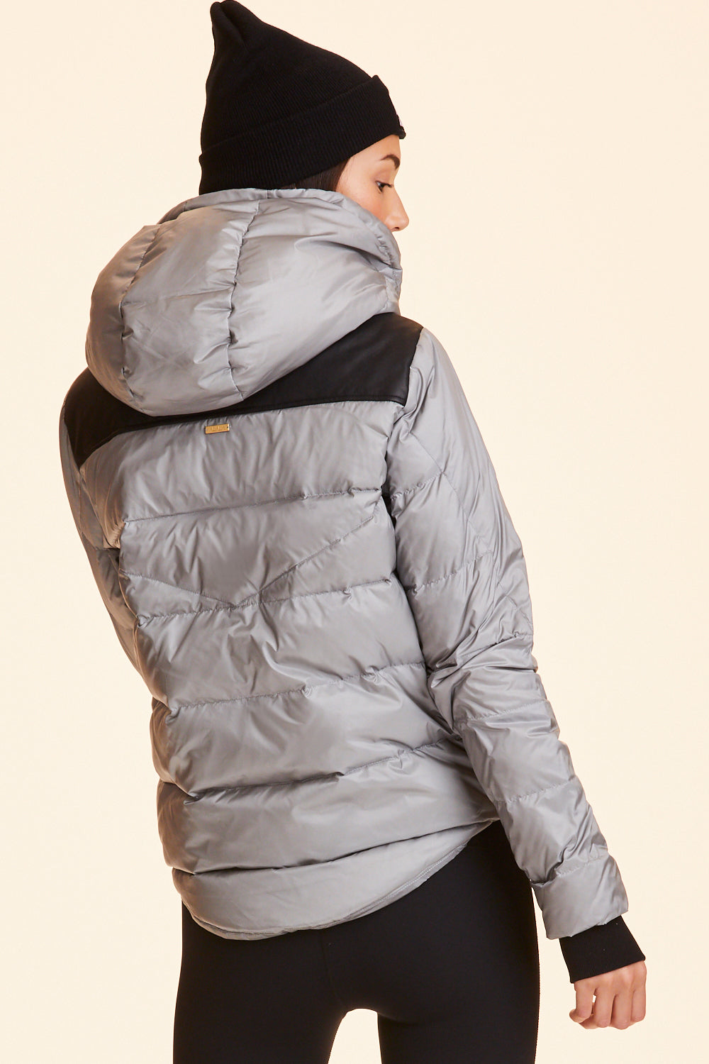 Back view of Alala Women's Luxury Athleisure silver puffer jacket