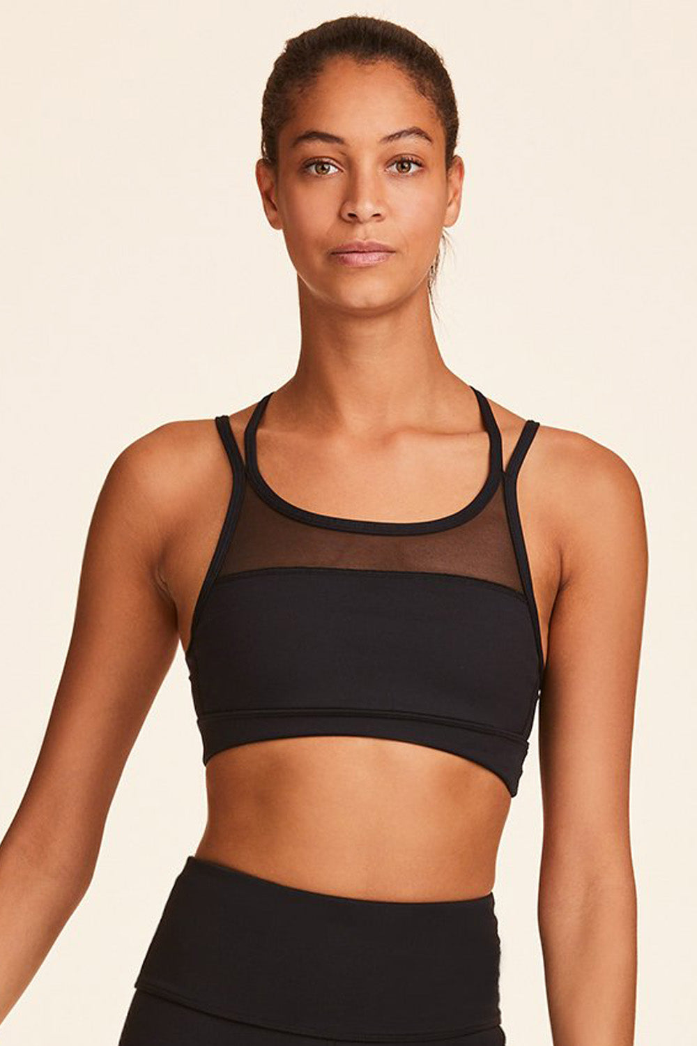 Front view of Alala Women's Luxury Athleisure blocked sports bra with criss-crossed straps in black