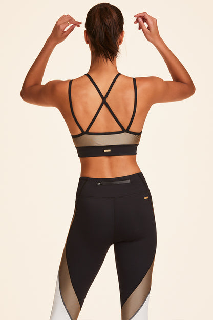 Back view of Alala Women's Luxury Athleisure blocked sports bra with criss-crossed straps in gold, white, & black