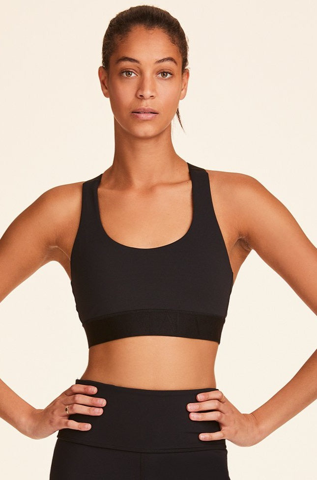 Front view of Alala Women's Luxury Athleisure black sports bra with cross back straps