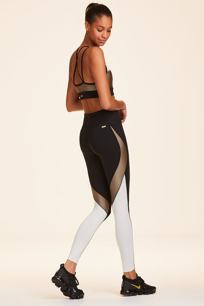 3/4 back view of Alala Women's Luxury Athleisure black, white, and gold color-blocked tight
