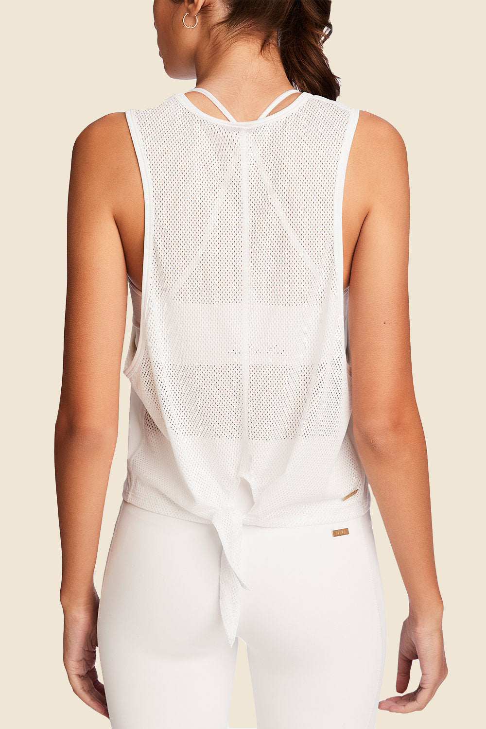 Back view of Alala Women's Luxury Athleisure mesh tie back tank in white with mesh detailing