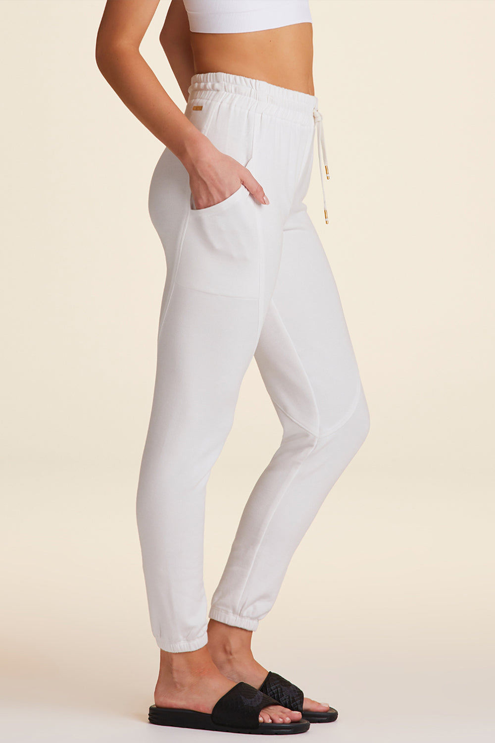 Side view of Alala Luxury Women's Athleisure super crewneck fleece sweatpant in white with pockets