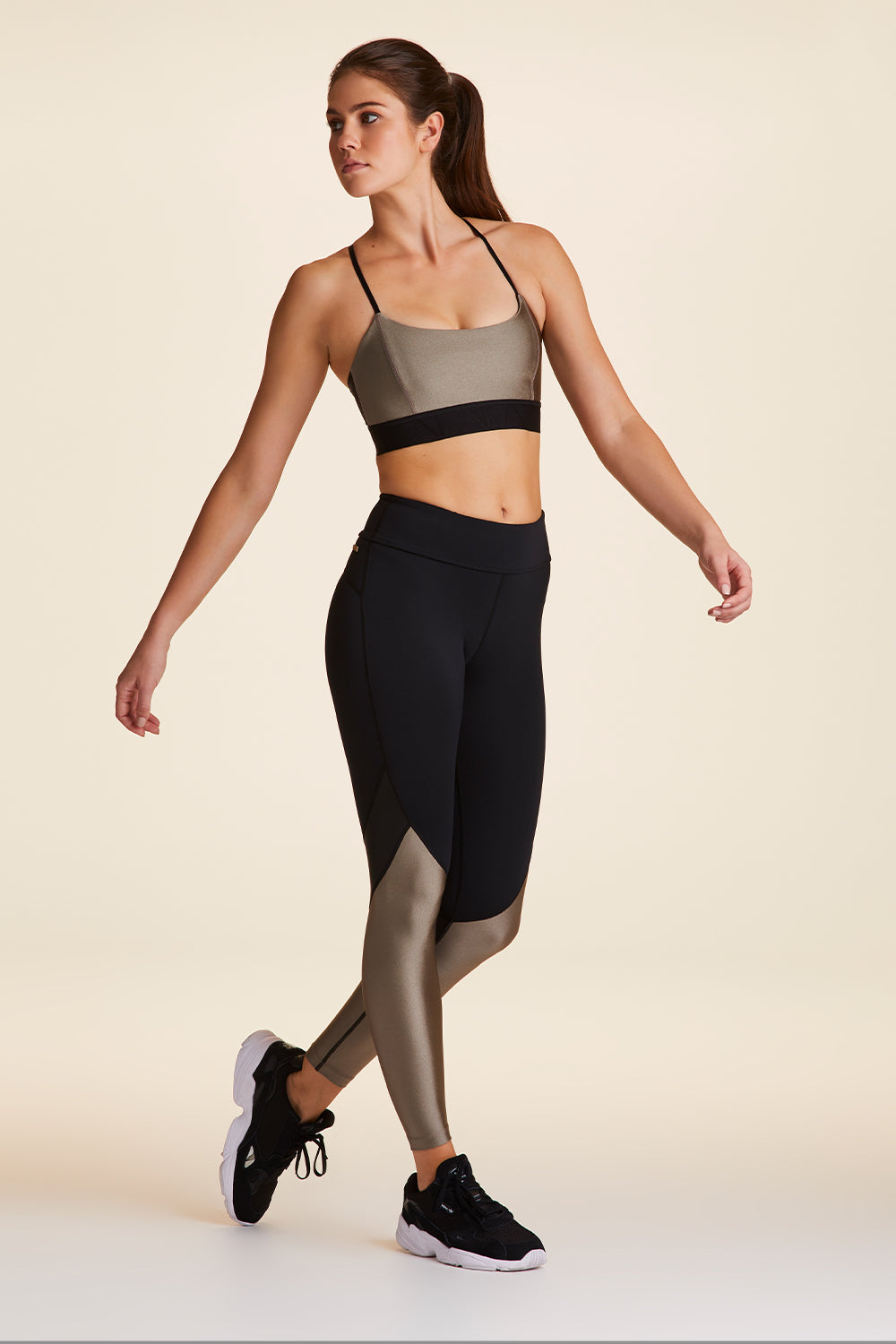 Full body front view of Alala Luxury Women's Athleisure captain ankle tight in black and gold dust