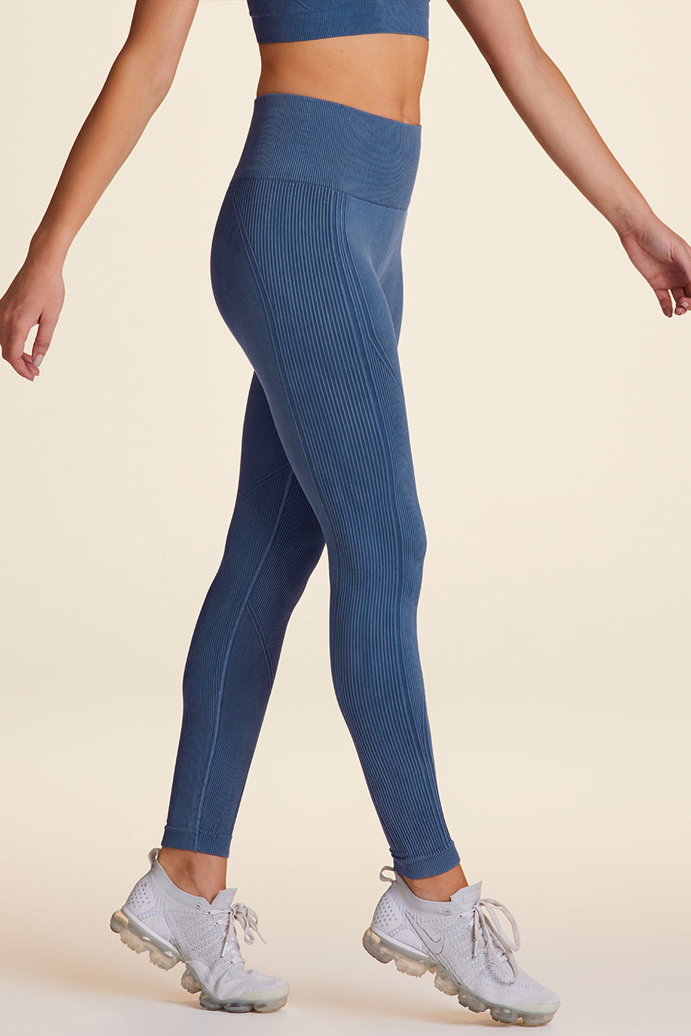 Side view of Alala Women's Luxury Athleisure flow seamless tight in blue with rib detailing