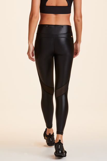 Back view of Alala Women's Luxury Athleisure shiny black tight with mesh paneling on back of knees