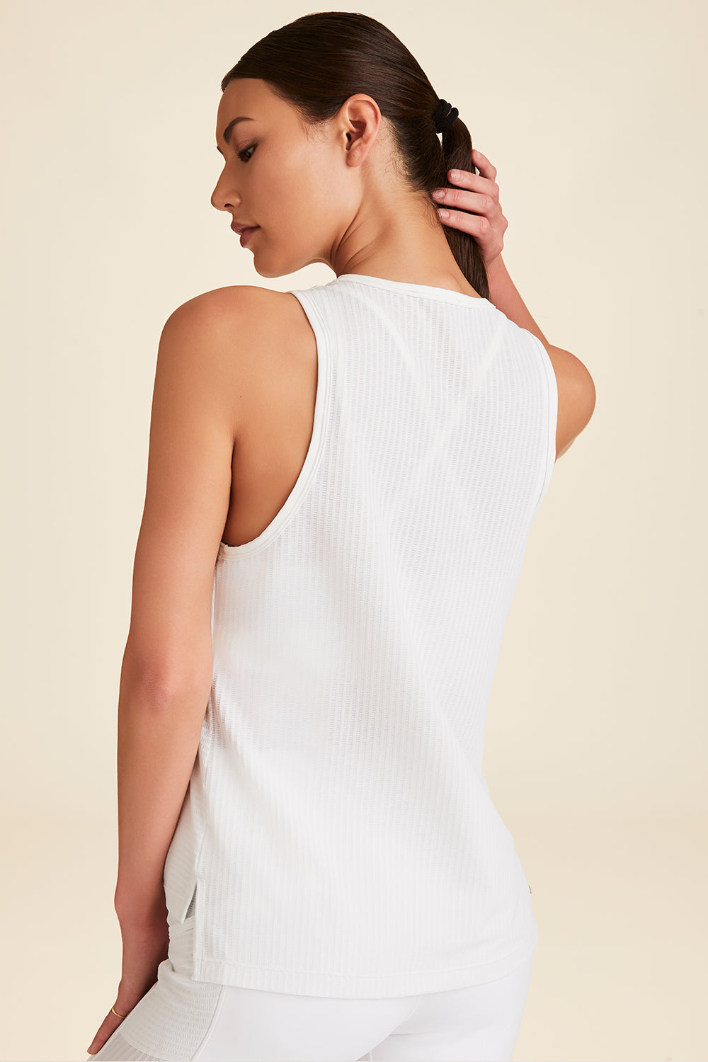 Closeup from back of woman modeling back of white Mirage Tank showing length and fit