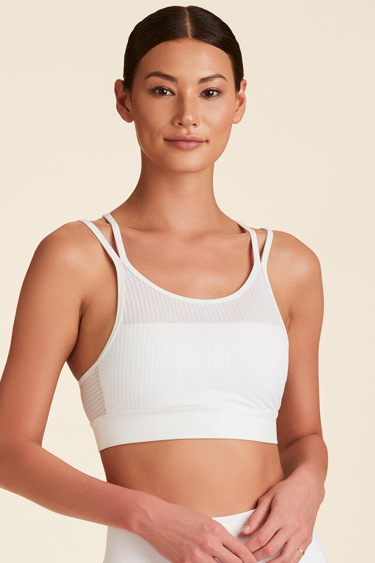 Front closeup of model with hands in front wearing Mirage Cami Bra in white
