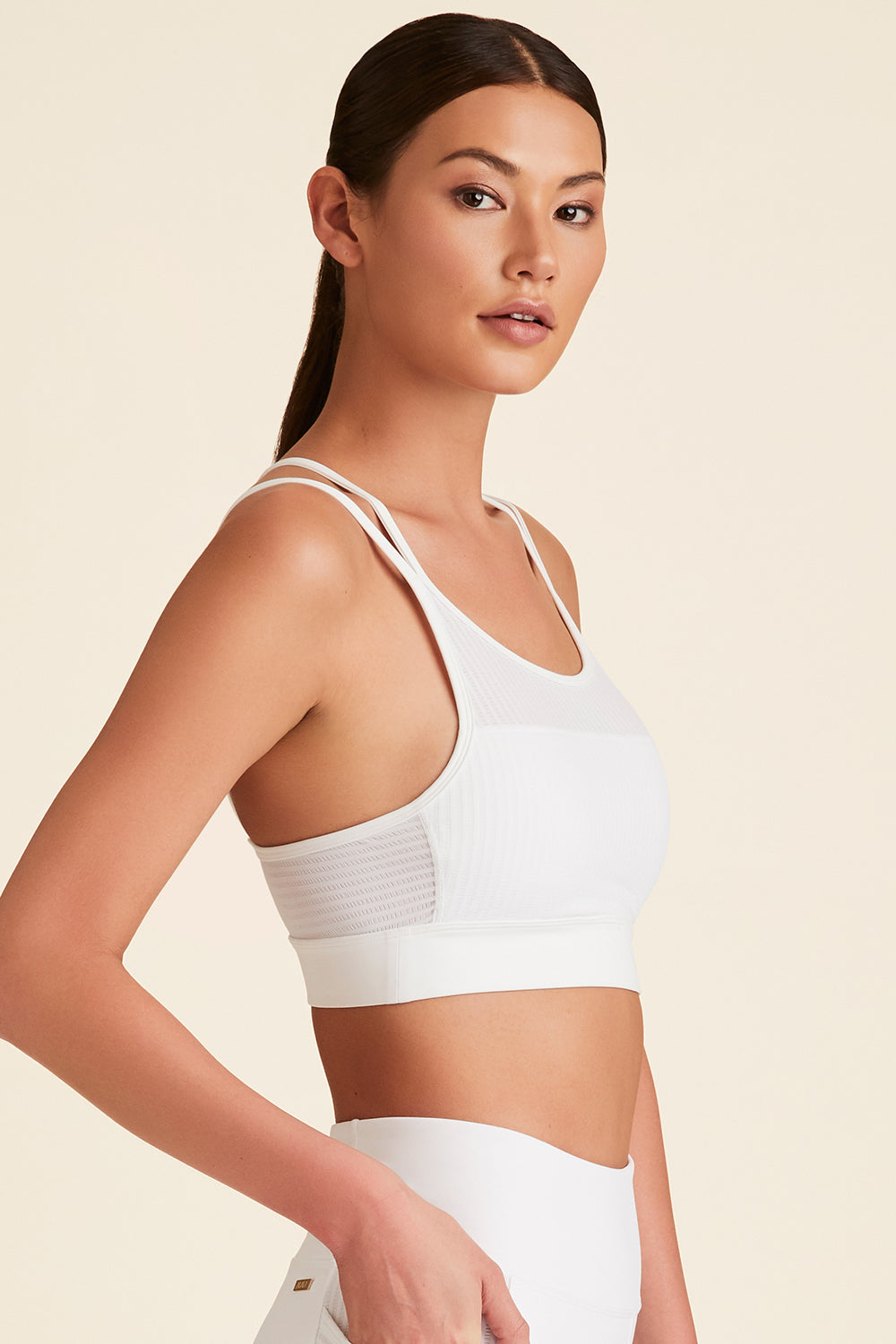 Side view of model wearing white Mirage Cami Bra with breathable side fabric visible