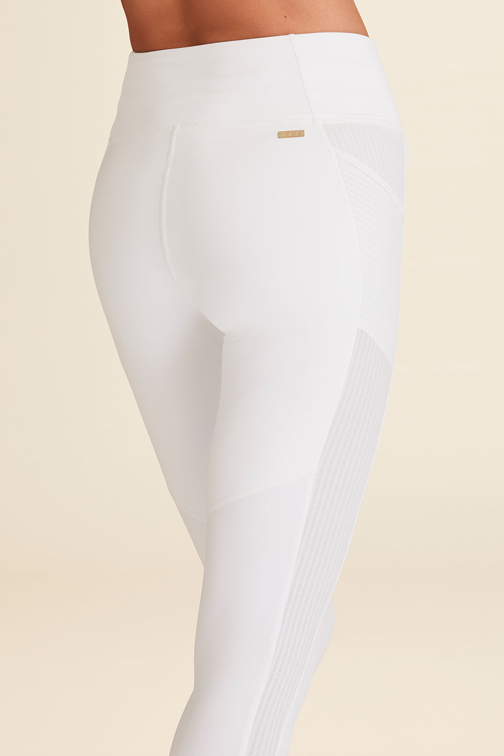Closeup of lower body of woman modeling white Mirage Tight to show fit around backside