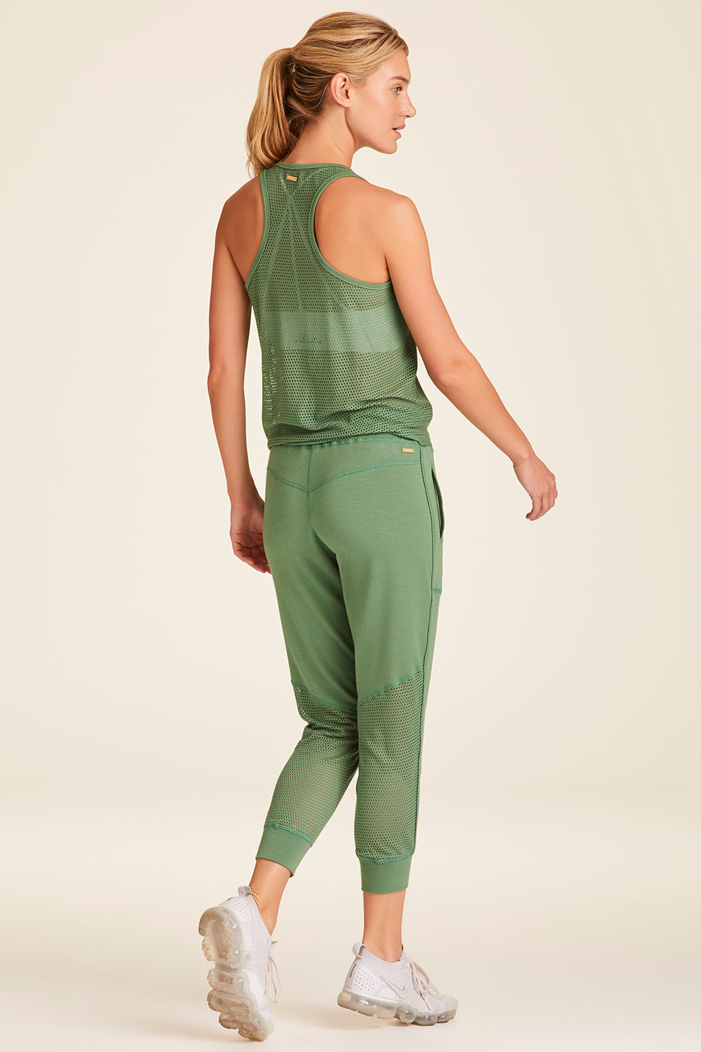 Full body back view of Alala Luxury Women's Athleisure heron jogger in agave green