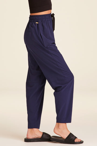 Side view of Alala Luxury Women's Athleisure commuter pant in navy