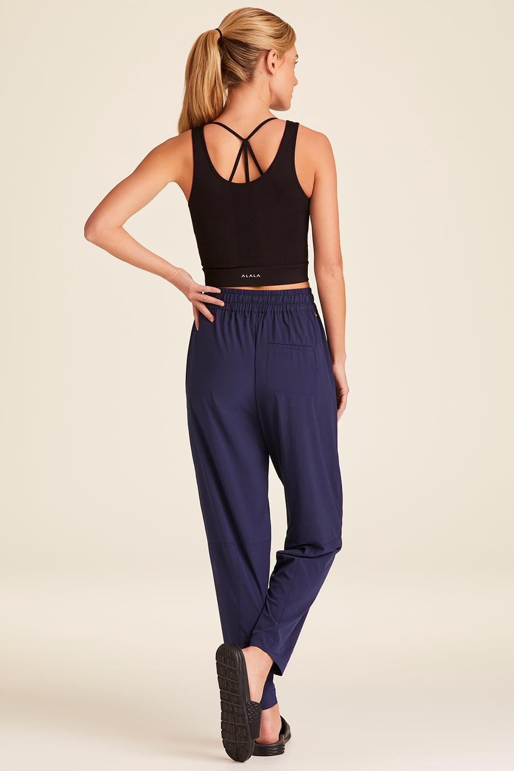 Full body back view of Alala Luxury Women's Athleisure commuter pant in navy