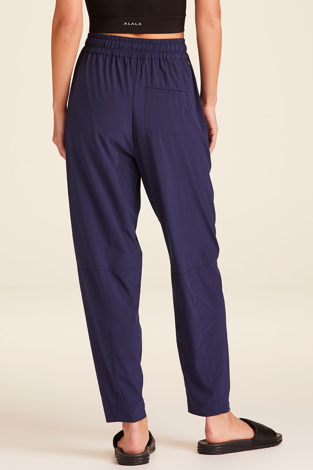 Back view of Alala Luxury Women's Athleisure commuter pant in navy