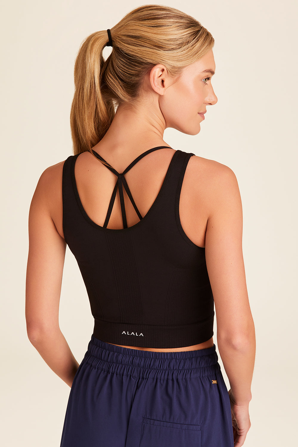 Back view of Alala Luxury Women's Athleisure seamless knit V-neck crop tank in black
