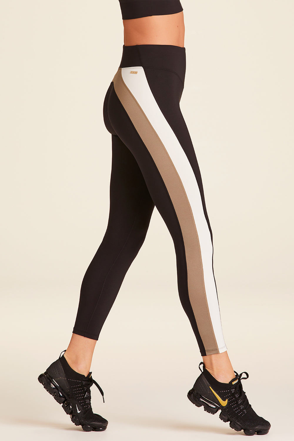 Side view of Alala Luxury Women's Athleisure bolt tight in black, gold, and bone