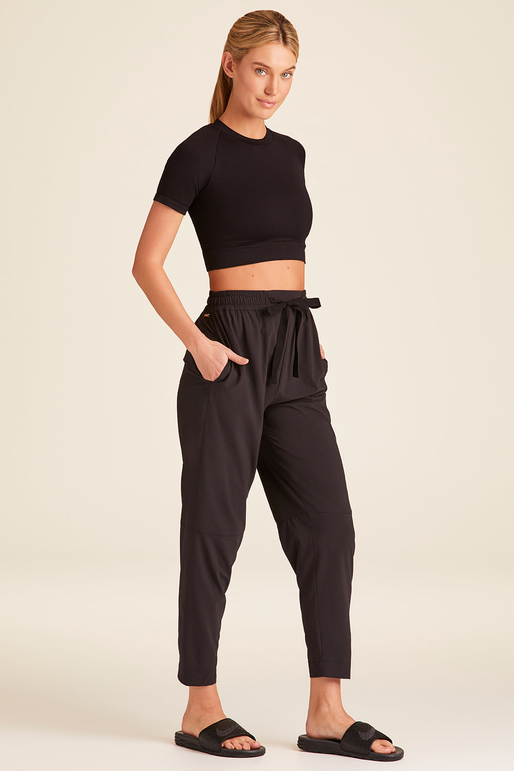 Full body front view of Alala Luxury Women's Athleisure commuter pant in black