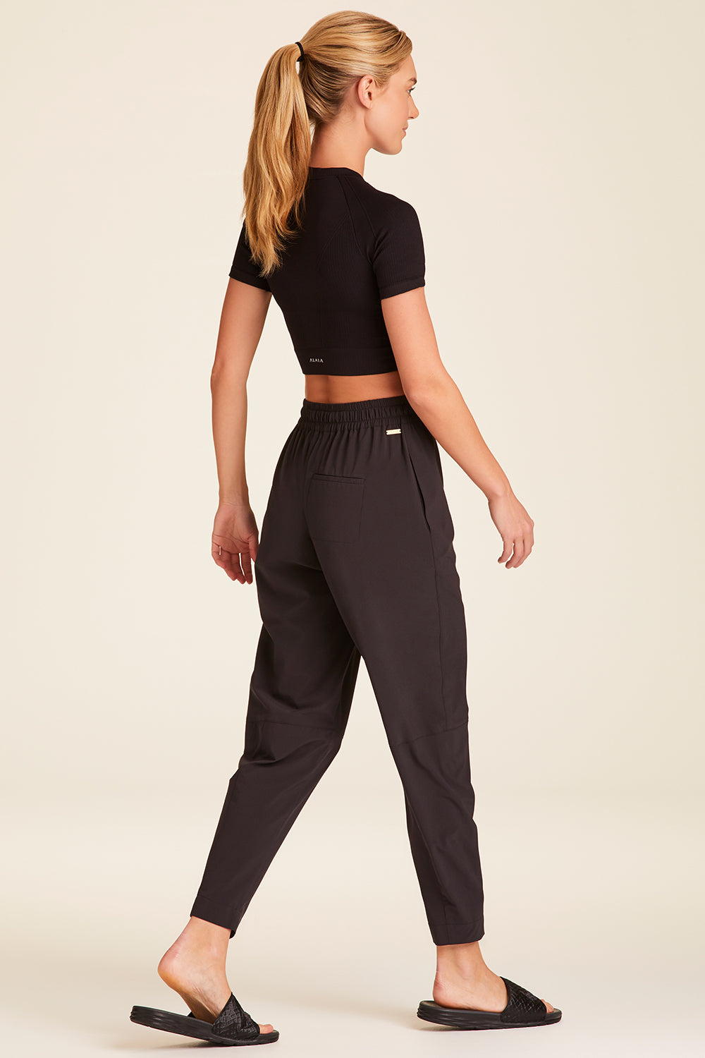 Full body back view of Alala Luxury Women's Athleisure commuter pant in black