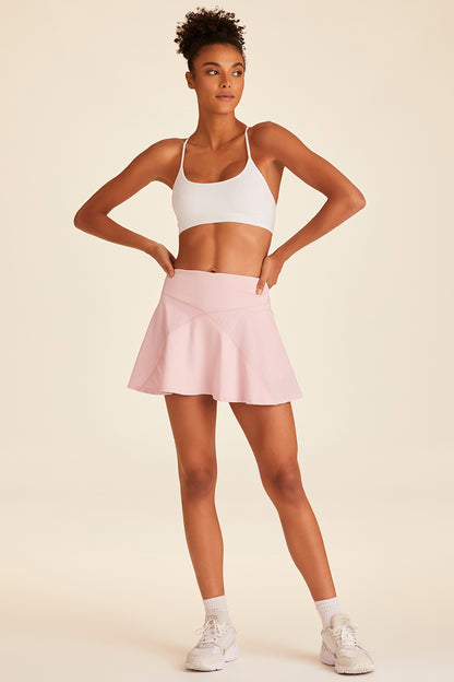 Full body view of model with hands on hips wearing powder pink Rally Skort